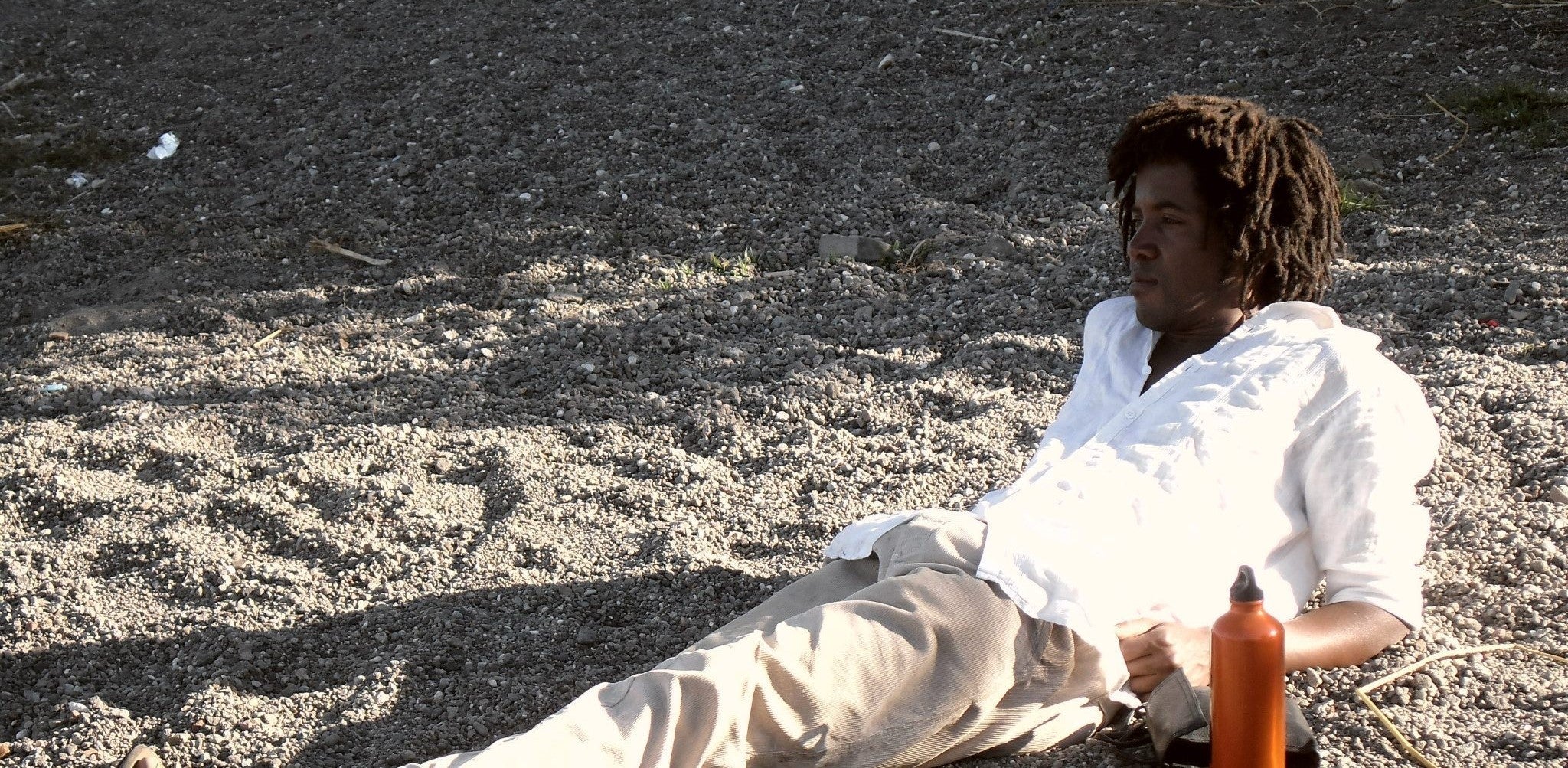 Young man reflecting on life listening to waves on the beach. 